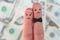 Fingers art of couple on background of money. Concept of wedding, woman and man needs to get married, but they don`t want.