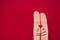 fingers coupled together with a painted heart, a cheerful smile, smileys, emojis, isolated on red background, the symbol of love