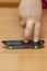 Fingers on a fingerboard on a wooden surface, close-up, selective focus. Fingerskate finger training.