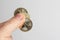 Fingers holding three Ukrainian coins on a light background