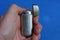 Fingers holds a gray metal lighter