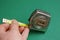 Fingers holds a yellow metal ruler on a construction tape measure