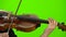 Fingers of the musician clamp the strings on a wooden violin . Green screen. Close up