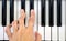 Fingers play chords on piano keys playing synthesizer pianist music hobby top view