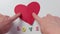 fingers separating two halves of red paper heart on white word love letters