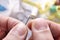 Fingers of a tailor threading a needle