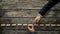 Fingers walking across planks with hand underneath