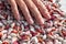 Fingers of a young woman\\\'s hand stirring a pile of pinto kidney beans