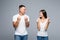 Finish. Portrait of glad positive couple in casual outfits with raised arms celebrating victory isolated on grey background