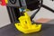 Finished 3D printed model of yellow PLA ship. Detail of printhead with fan and hotend.