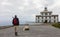 The Finisterre lighthouse with a pilgrim in the foreground.