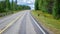 Finland. View of a scenic road passing through a forest. Beautiful Scandinavian landscape. Deer cross the road