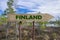 Finland wooden arrow road sign against swamp or bog