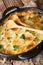 Finnish cuisine Janssonin Kiusaus. Baked potatoes with anchovies, onions and cream close-up in a frying pan on the table