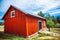 Finnish farm with old red wooden barns at countyside summer sunny day, green grass, blue sky and bushes of black currant, agricul