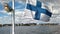 Finnish flag at the stern of the ship against the sky and the view of Helsinki.