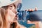 Fintess woman drinking water. Happy, active middle aged woman standing on beach and drinking water after excersise