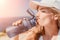 Fintess woman drinking water. Happy, active middle aged woman standing on beach and drinking water after excersise