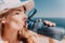 Fintess woman drinking water. Happy, active middle aged woman standing on beach and drinking water after excersise