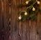 Fir branch with vintage garland on wooden background.christmas atmosphere.