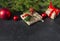 Fir branches,  gift box tied with a rope, red balls, red berries on a black background, Christmas