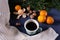 Fir branches on a table near tangerines, white sweater, coffee mug and nuts