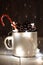 Fir cones in tin jar with sparkling star-shaped garland and single candy cane stick. Christmas decorations.