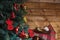 fir-tree branches with red and golden bulbs, cones, angel toys. Wreath with dry lemon slices and cotton flower on the plaid