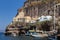 FIRA, GREECE - JUNE 16, 2019: Beautiful view of the Old Port in Fira town with the sailboat  ship in the foreground, Santorini,