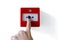Fire alarm trigger button being pressed by finger