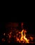Fire on a black background. Red, orange and yellow flames and sparks on a dark background. Bonfire, fireplace, hearth or fire