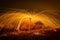 Fire dancer swing fire dancing show on the beach with dark clouds, twilight sky background.