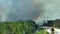 Fire department chopper and firetrucks extinguishing wildfire burning severely in Florida jungle woods. Emergency