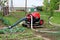 Fire department large petrol water pump connected with multiple strong fire hoses used to pump flood water out of local garden