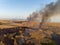 Fire destroys the fields of dry reeds along the shore of the sea. Bird`s eye view