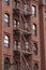 Fire escape stairs-downtown back alley architecture-steel and red brick background