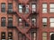 Fire Escape stairs on red brick classic building wall.