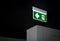 Fire exit sign. Green electric emergency evacuation escape sign with illuminated light.