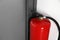 Fire extinguisher near door indoors. Space for text
