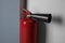 Fire extinguisher near light wall indoors, closeup