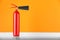 Fire extinguisher near orange wall, space for text