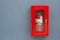 Fire Extinguisher in red cabinet on gray wall at external buildings.