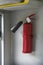 Fire extinguisher in vestibule of an electric train car hangs on wall