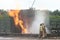 Fire fighter with fire hose at a fire incident, suppressing the blaze