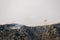 A fire fighting water bomber dropping water on a forest fire on top of the Kozjak mountain in Croatia. Summer wildfires are very