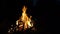 Fire in a fireplace. Burn fire with wood and legs outdoor. Campfire in the night forest while camping