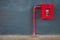 Fire hose in red box, pipe roll for fire emergency in red metal cabinet on gray painted concrete wall with tiled floor as part of