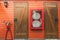 Fire hose in red cabinet hanging on orange wooden wall. Fire emergency equipment box for safety and security system. Fire safety