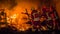 Fire men push rests of a falla into the fire during Las Fallas in Valencia Spain