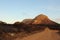 Fire ravaged burnt, arid wilderness landscape covered in small protea shrubs, with a dirt road